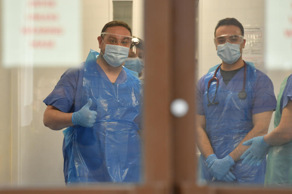 Medical staff wearing personal protective equipment (PPE) wait to receive coronavirus patients at the door of the Respiratory Assessment Unit at the Morriston Hospital in Swansea, as the health services prepare their response to the coronavirus outbreak.