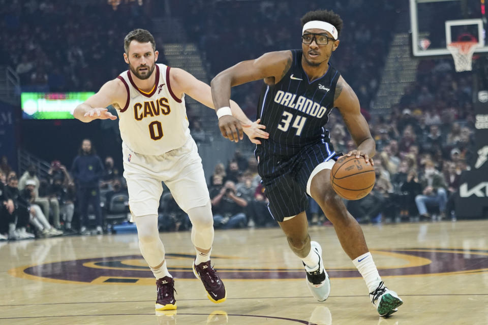 Orlando Magic's Wendell Carter Jr. (34) drives against Cleveland Cavaliers' Kevin Love (0) in the first half of an NBA basketball game, Saturday, Nov. 27, 2021, in Cleveland. (AP Photo/Tony Dejak)