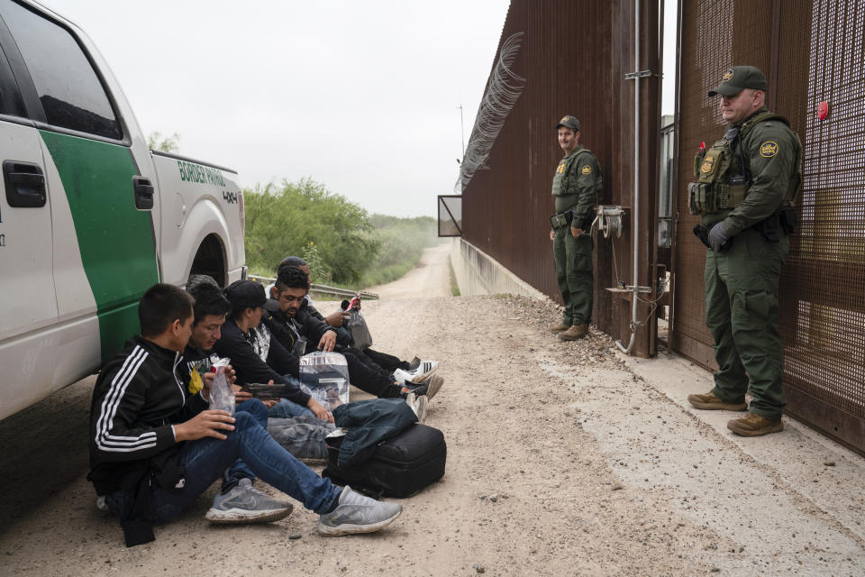 Colombian migrants that were trying to evade U.S. Border Patrol wait to be processed near the port of entry in Hidalgo, Texas, Thursday, May 4, 2023. (AP Photo/Veronica G. Cardenas)