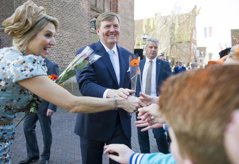 Netherlands' King Willem Alexander, right, thanks well wishers as Queen Maxima, left, looks at festivities marking King's Day in De Rijp, 36 kilometers (22 miles) north of Amsterdam, Netherlands, Saturday, April 26, 2014. The Dutch marked King's Day on Saturday, a national holiday held in honor of the newly installed monarch, King Willem Alexander. King's Day replaces the traditional Queen's Day. (AP Photo/Patrick Post)