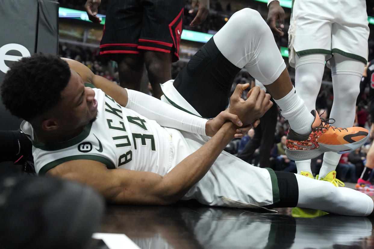 Giannis Antetokounmpo grabs his right wrist after injuring it during the Bucks' game against the Bulls on Thursday. (AP Photo/Charles Rex Arbogast)