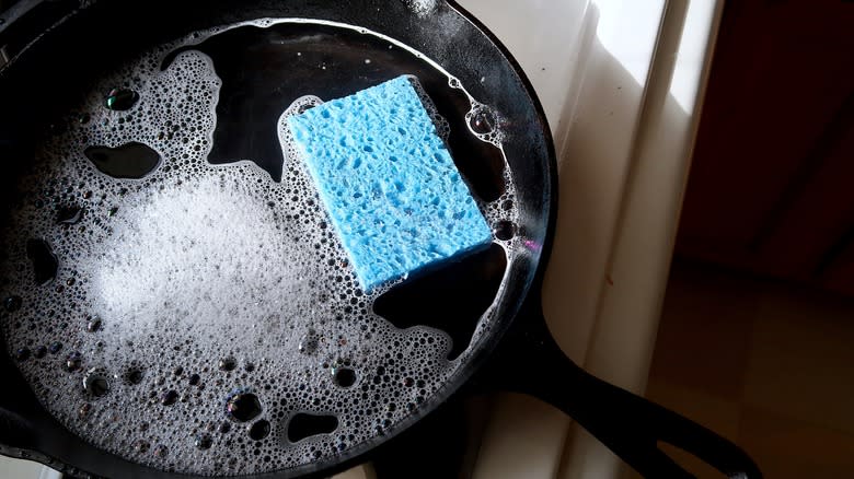 Cast iron pan with soapy sponge