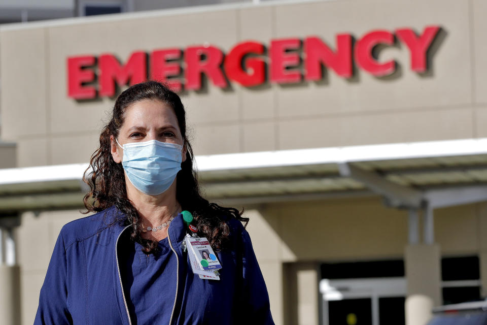 Caroline Maloney stands outside HonorHealth's Scottsdale Osborn Medical Center at the end of her overnight shift early Friday, June 26, 2020 in Scottsdale, Ariz. Arizona nurses and doctors find themselves on the frontline as the coronavirus rips through the state, making it one of the world's hot spots. (AP Photo/Matt York)