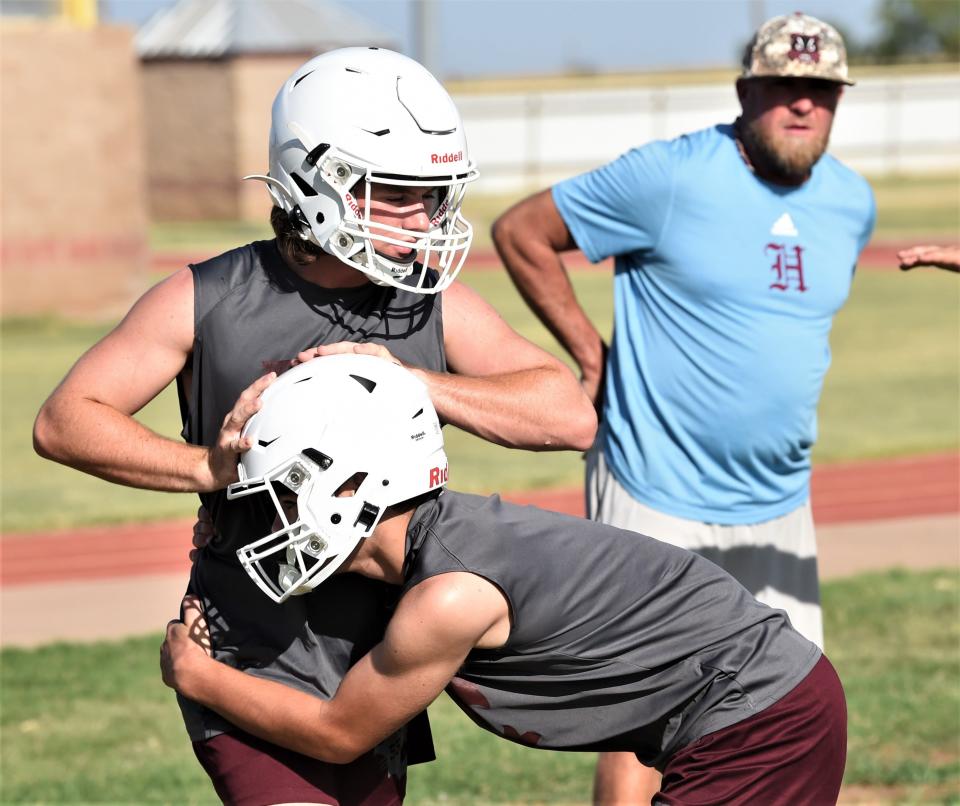 Hawley players work on a drill while assistant Jamie Seago looks on during the first day of fall practice.