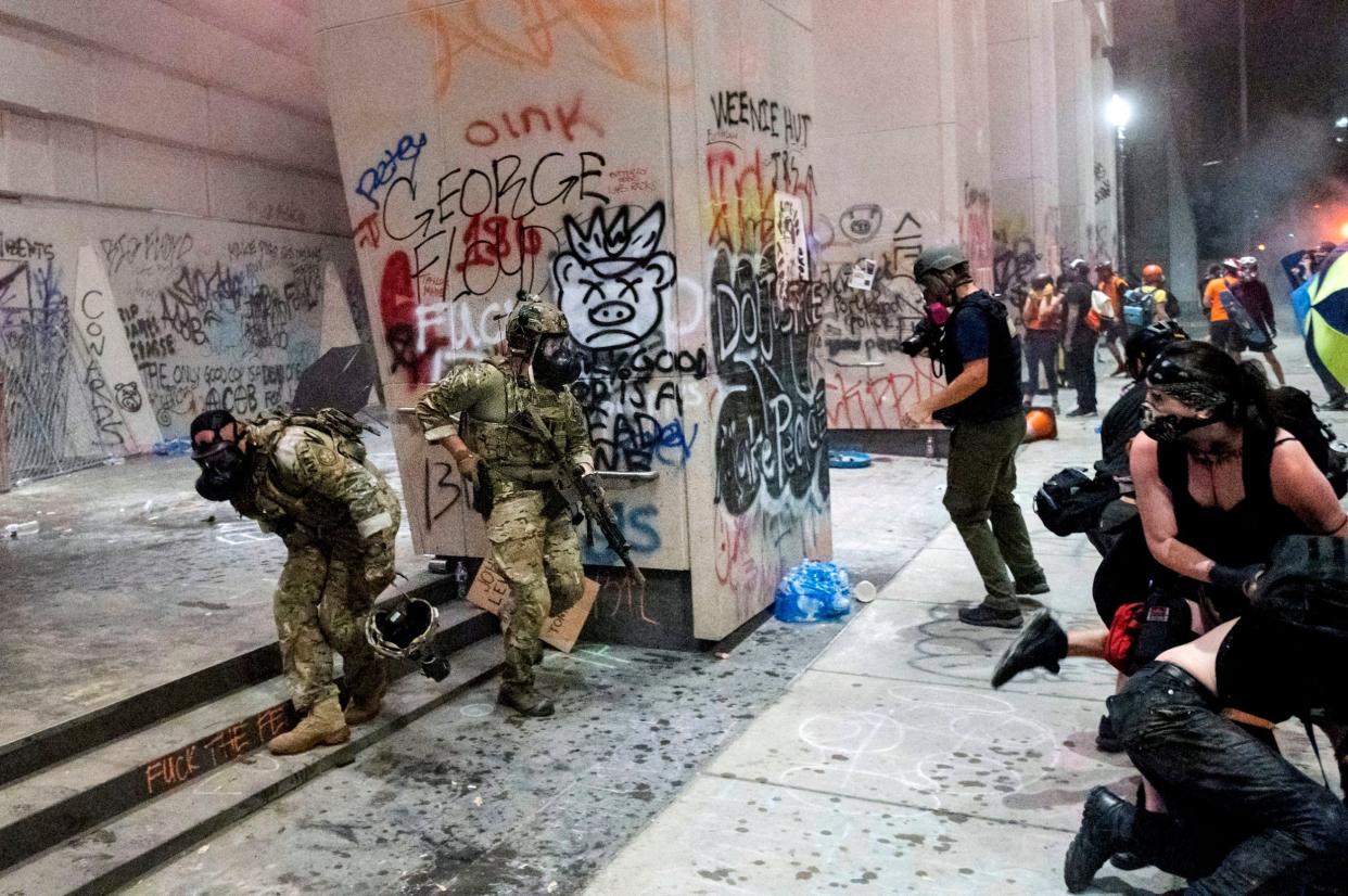 Federal officers disperse protesters at the Mark O. Hatfield United States Courthouse in Portland, Oregon, during demonstrations in favour of racial justice and against militarised federal officers making arrests: AP