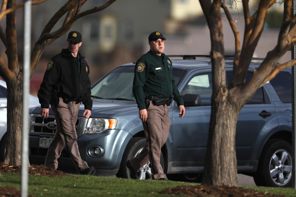 Jefferson County Sheriff's Department deputies walk the parking lot as participants arrive to attend a faith-based memorial service for the victims of the massacre at Columbine High School nearly 20 years ago at a community church Thursday, April 18, 2019, in Littleton, Colo. (AP Photo/David Zalubowski)