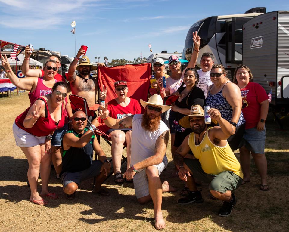 The "Go-Go Clan" poses for a photo around Mary Dunton in her oversized camp chair at their campsite in The Resort camping area at Stagecoach at the Empire Polo Club in Indio, Calif., Saturday, April 29, 2023. 