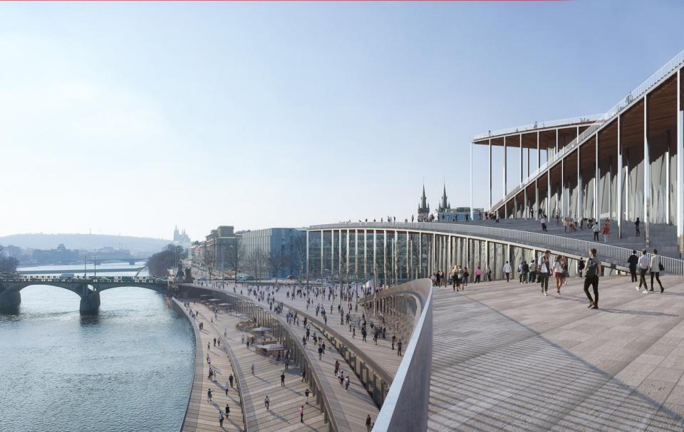 Pedestrians walk alongside the riverside Vltava Philharmonic Hall in Prague.