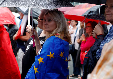 Woman is wrapped in the European Union flag as she takes part in an anti-government protest in support of free courts outside the Parliament building in Warsaw, Poland July 18, 2018. REUTERS/Kacper Pempel