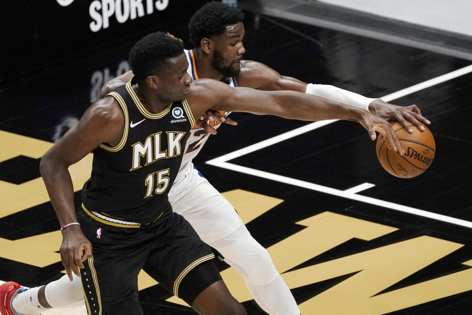 Phoenix Suns center Deandre Ayton (22) and Atlanta Hawks center Clint Capela (15) fight for a loose ball in the first half of an NBA basketball game Wednesday, May 5, 2021, in Atlanta. (AP Photo/John Bazemore)
