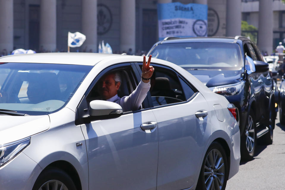 President-elect Alberto Fernandez flashes a victory sign as he drives to Congress to take the oath of office in Buenos Aires, Argentina, Tuesday, Dec. 10, 2019. (AP Photo/Marcos Brindicci)