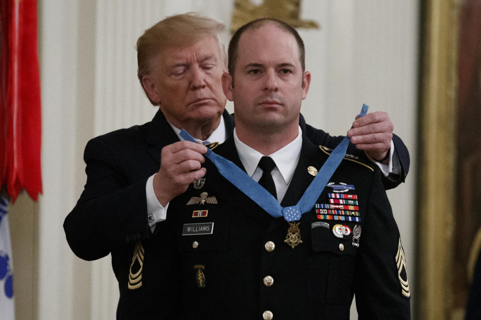 President Donald Trump places the Medal of Honor on Army Master Sgt. Matthew Williams, currently assigned to the 3rd Special Forces Group, during a Medal of Honor Ceremony in the East Room of the White House, Wednesday, Oct. 30, 2019, in Washington. (AP Photo/Alex Brandon)