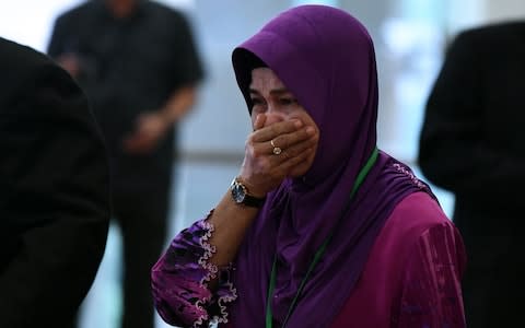 Sarah Nor, the mother of Norliakmar Hamid, a passenger on missing Malaysia Airlines flight MH370, cries as she arrives for the final investigation report - Credit:  MOHD RASFAN/ AFP