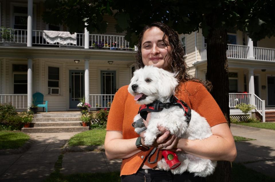 Sydney Hunt with her dog, Carter, in front of their first-floor apartment home on Pleasant Valley Parkway in Providence.