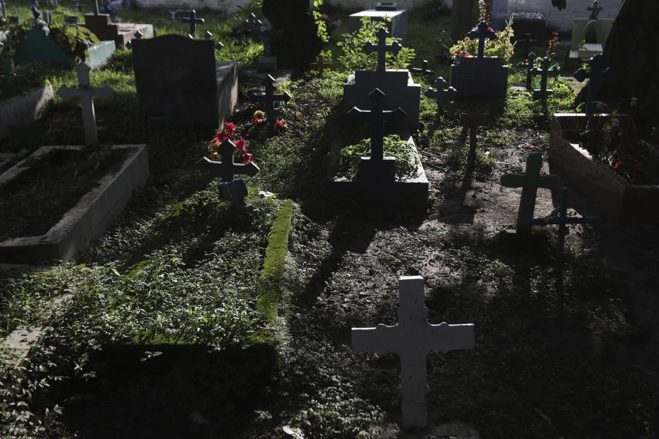 Crosses adorn the graves of people who died in Los Angelitos in a landslide triggered by an October 2020 tropical storm, in the Municipal Cemetery in Nejapa, El Salvador, Sunday, Aug. 1, 2021. They were among eleven people who died as 78 homes on the slopes of the San Salvador volcano were demolished. (AP Photo/Salvador Melendez)