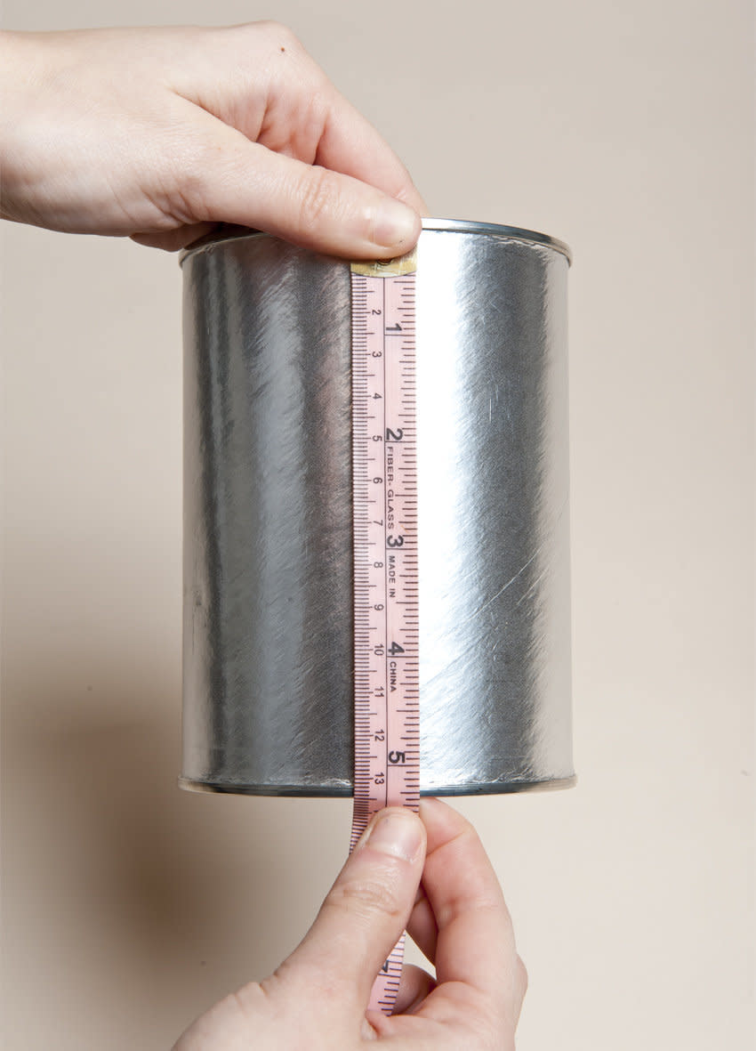 Take your ruler and measure the height of the can. This will help when you're re-wrapping it with the decorative paper. 