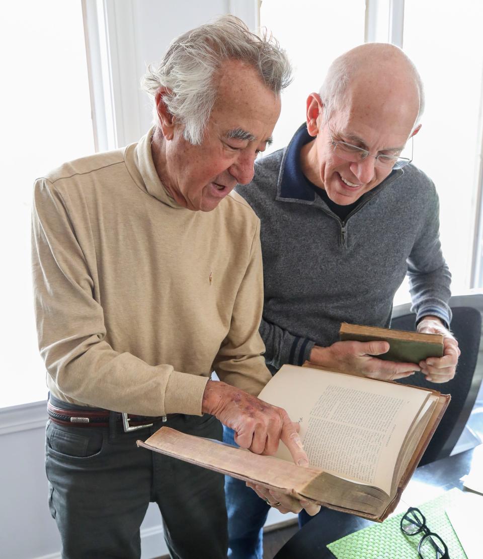 Michael and Mark Perelmuter with books checked out from the Louisville Free Public Library almost a century ago by members of his family.