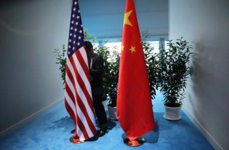 FILE PHOTO - Chinese official prepares the flags for the China-USA bilateral meeting at the G20 leaders summit in Hamburg, Germany July 8, 2017. REUTERS/Carlos Barria