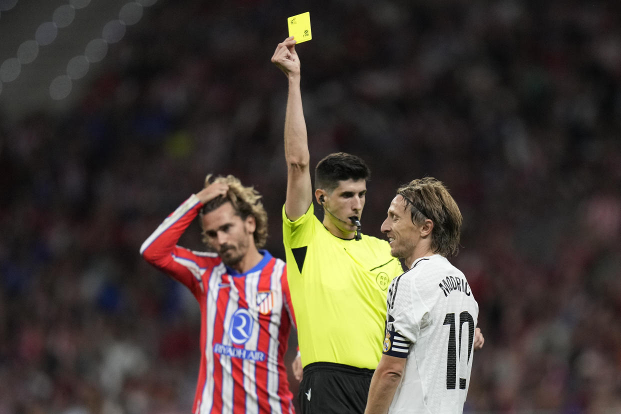 Real Madrid's Luka Modric receives a yellow card during the La Liga soccer match between Atletico Madrid and Real Madrid at the Metropolitano stadium in Madrid, Spain, Sunday, Sept. 29, 2024. (AP Photo/Bernat Armangue)