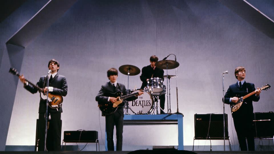 The Beatles (from left to right), Paul McCartney (playing the stolen bass), George Harrison, Ringo Starr and John Lennon perform during a concert on July 29, 1965. - Central Press/AFP/Getty Images