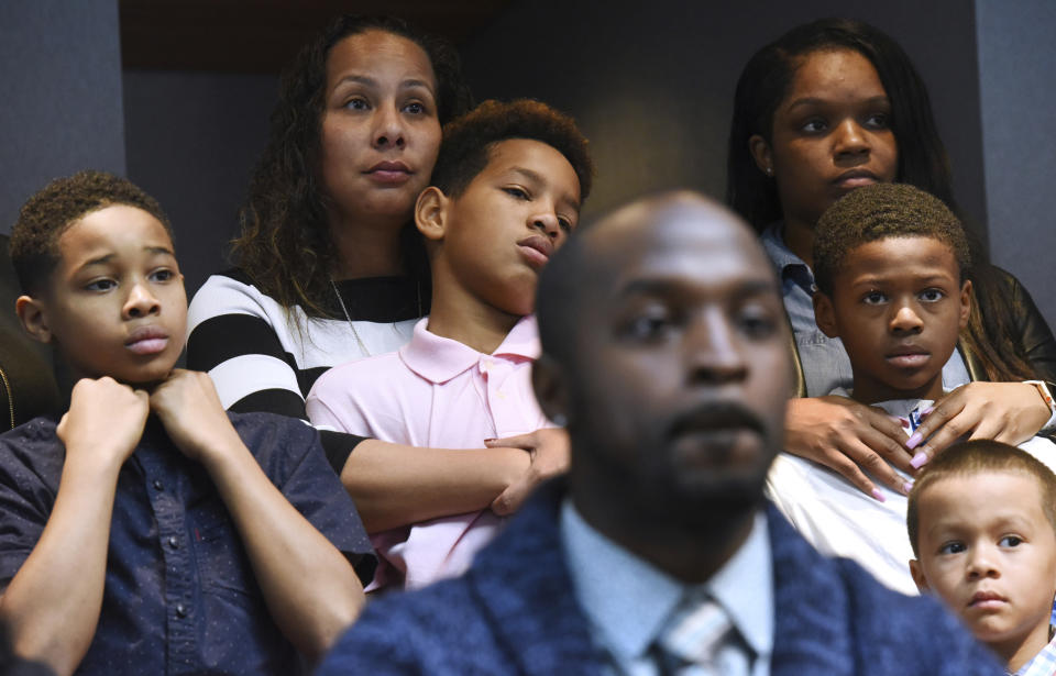 Marcus Riley of Bolingbrook, Ill., foreground, speaks during a press conference Tuesday, Nov. 5, 2019 in Aurora, Ill., about how he and other families, background, were asked to move because others didn't want to sit by them at a Naperville, Ill., Buffalo Wild Wings restaurant. (Paul Valade/Daily Herald via AP)