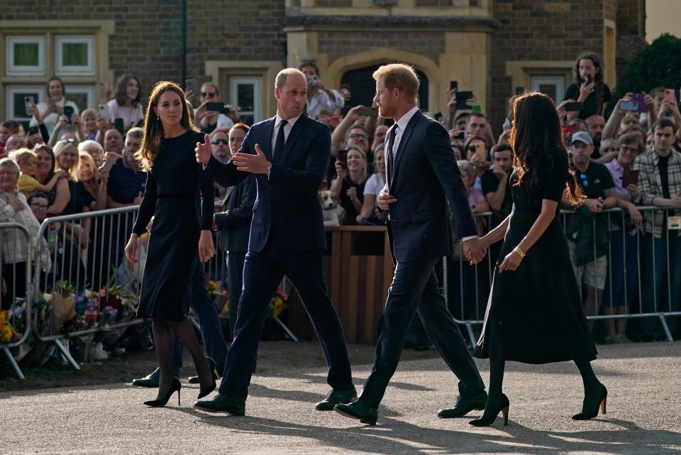 Prince William and Kate, Princess of Wales, left, and Britain's Prince Harry and Meghan, Duchess of Sussex walk to greet the crowds after viewing the floral tributes for the late Queen Elizabeth II (AP)