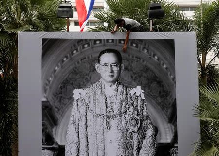 A worker installs a portrait of Thailand's late King Bhumibol Adulyadej outside the Royal Thai Police headquarters in Bangkok, Thailand, October 15, 2016. REUTERS/Edgar Su