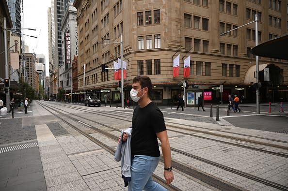 A Sydney man wears a mask on a near-deserted street in the central business district as people stay home due to the COVID-19 novel coronavirus outbreak.