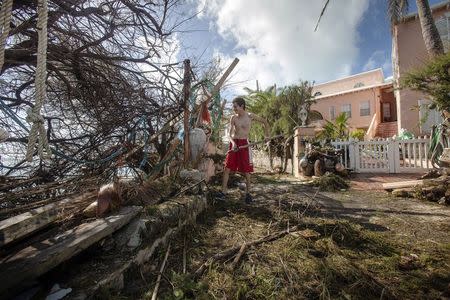 Stefano Ausenda shovels debris away from his driveway after Hurricane Gonzalo passed through in Sandys Parish, western Bermuda, October 18, 2014. REUTERS/Nicola Muirhead