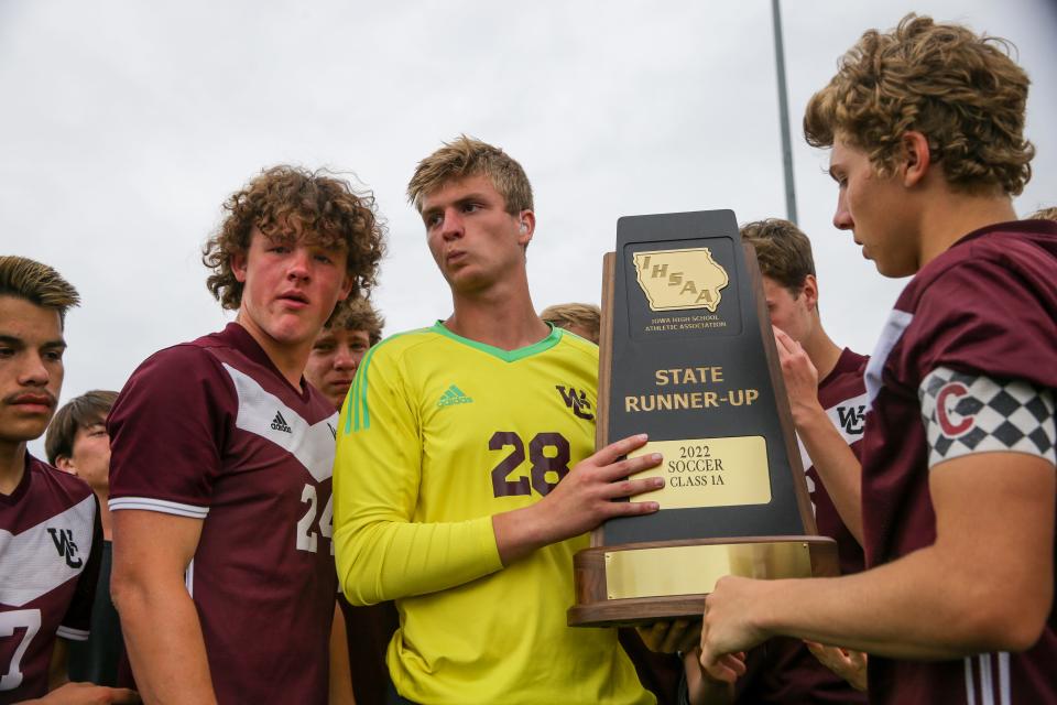 Western Christian's Ty Van Essen (28) and teammates hold the state participant trophy after the Wolfpack lost to Assumption during the Class 1A boys state soccer tournament championship.