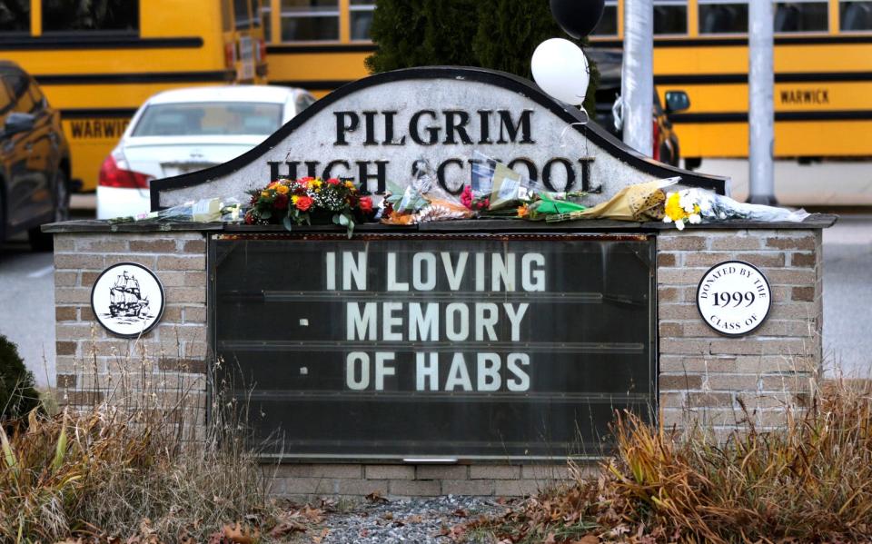 Flowers and balloons on the message board in front of Pilgrim High School on Monday pay tribute to principal Gerald Habershaw, who died Saturday of complications from COVID-19.