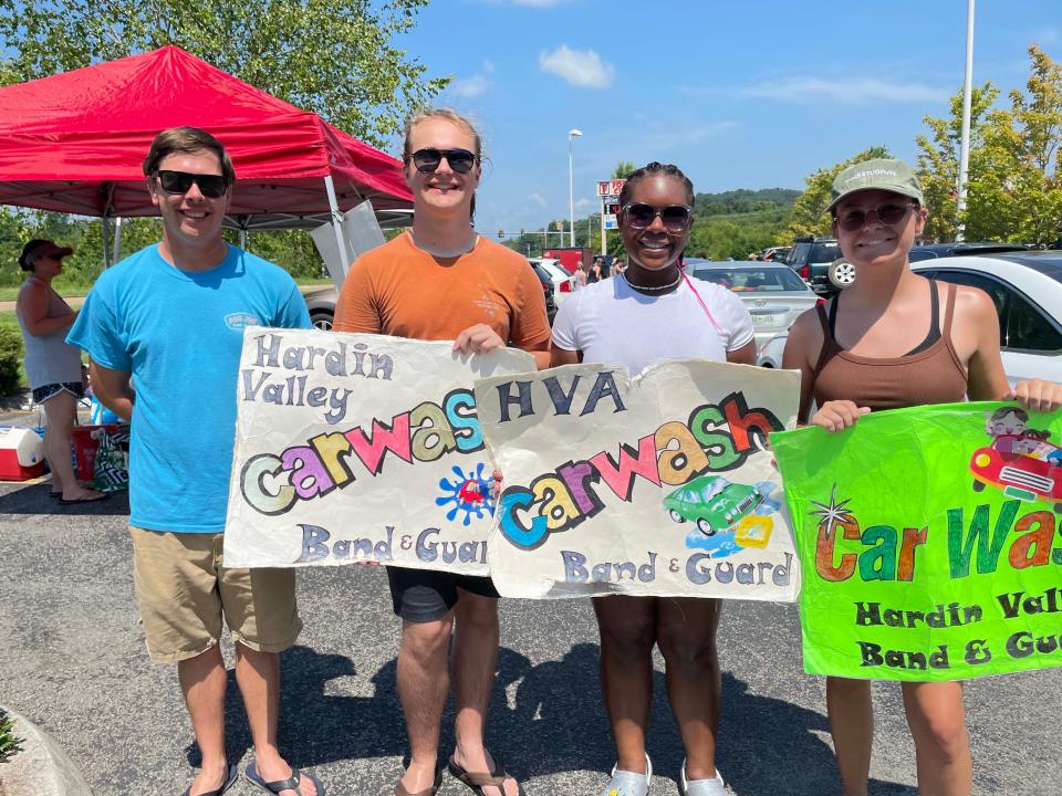 Band Director Alex Rector, left, with Aidan McAlester, Marnasia England and Christina Goethert, welcome hundreds of cars to the Hardin Valley Academy Band car wash at Food City on Middlebrook Pike Saturday, July 23, 2022.