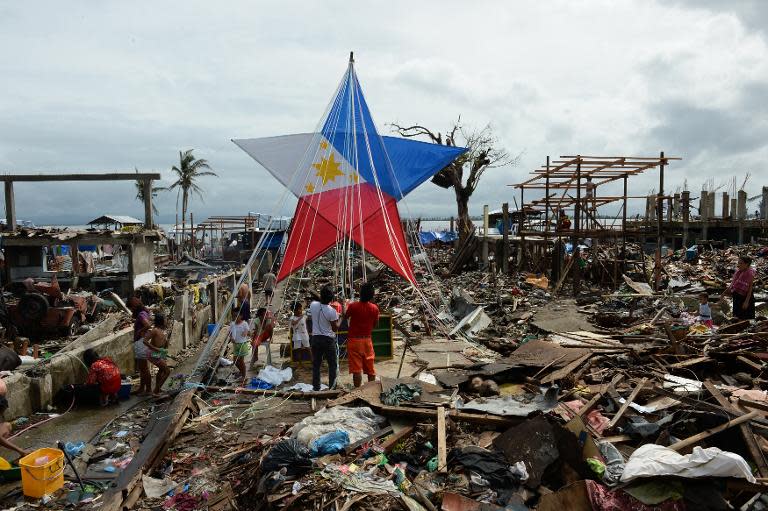 Residents and survivors of Super Typhoon Haiyan decorate a giant lantern in Tacloban, Philippines on December 24, 2013