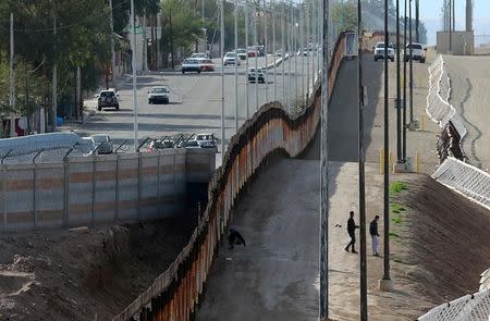 FILE PHOTO: Three men from India jump the fence from Mexico and give themselves up to U.S. border patrol agents in Calexico, California, U.S. on February 8, 2017. REUTERS/Mike Blake/File Photo