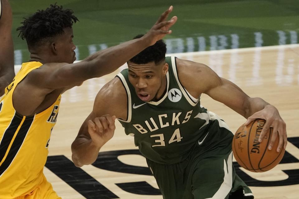 Milwaukee Bucks' Giannis Antetokounmpo tries to drive past Miami Heat's Jimmy Butler during the second half of Game 1 of their NBA basketball first-round playoff series Saturday, May 22, 2021, in Milwaukee. (AP Photo/Morry Gash)