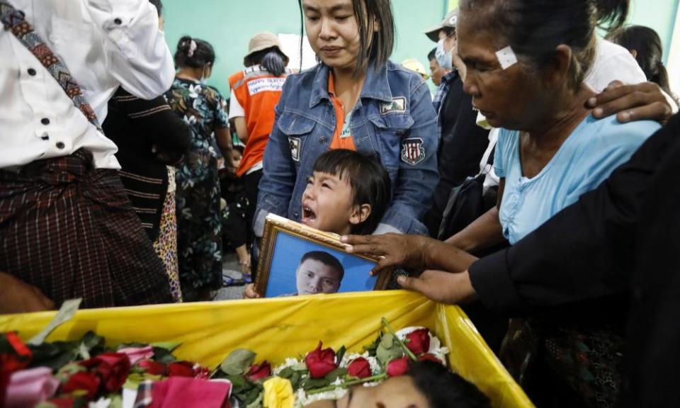 The daughter of Zwee Htet-soe, who died in the anti-coup protests, cries near the coffin of her father during his funeral in Yangon, Myanmar.