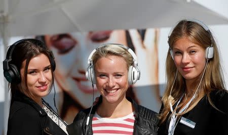 Models pose with the AKG K545 (L-R), JBL Synchros S300 and Harman/Kardon Soho headphones at the IFA consumer electronics fair in Berlin, September 6, 2013. REUTERS/Fabrizio Bensch