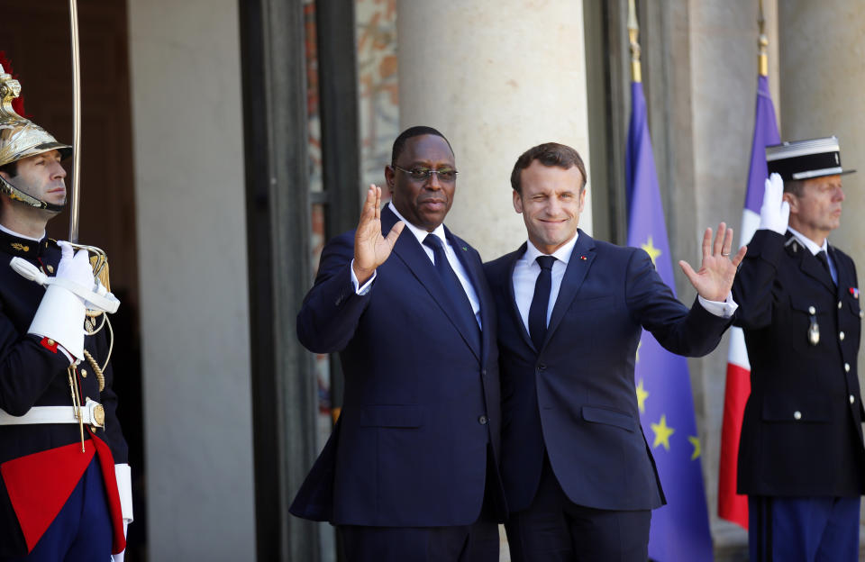 Senegal's President Macky Sall, center left, is greeted by French President Emmanuel Macron as he arrives at the Elysee Palace, in Paris, Wednesday, May 15, 2019. Several world leaders and tech bosses are meeting in Paris to find ways to stop acts of violent extremism from being shown online. (AP Photo/Francois Mori)