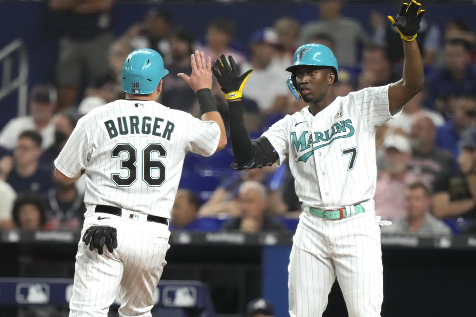 Miami Marlins' Jake Burger (36) is met by teammate Jesus Sanchez (7) after scoring on a single hit by Bryan De La Cruz during the first inning of a baseball game against the Atlanta Braves, Friday, Sept. 15, 2023, in Miami. (AP Photo/Lynne Sladky)