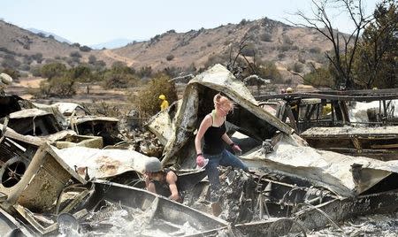 Emily Fryer, 20, searches for family heirlooms at her boyfriend's leveled home after the Erskine Fire burned through South Lake, California, U.S. June 26, 2016. REUTERS/Noah Berger