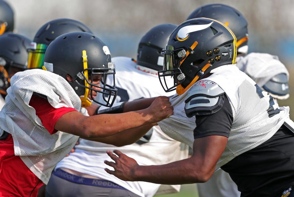 North defensive end T.Y. Jones, right, works against a teammate during football practice Aug. 3 at North High School.