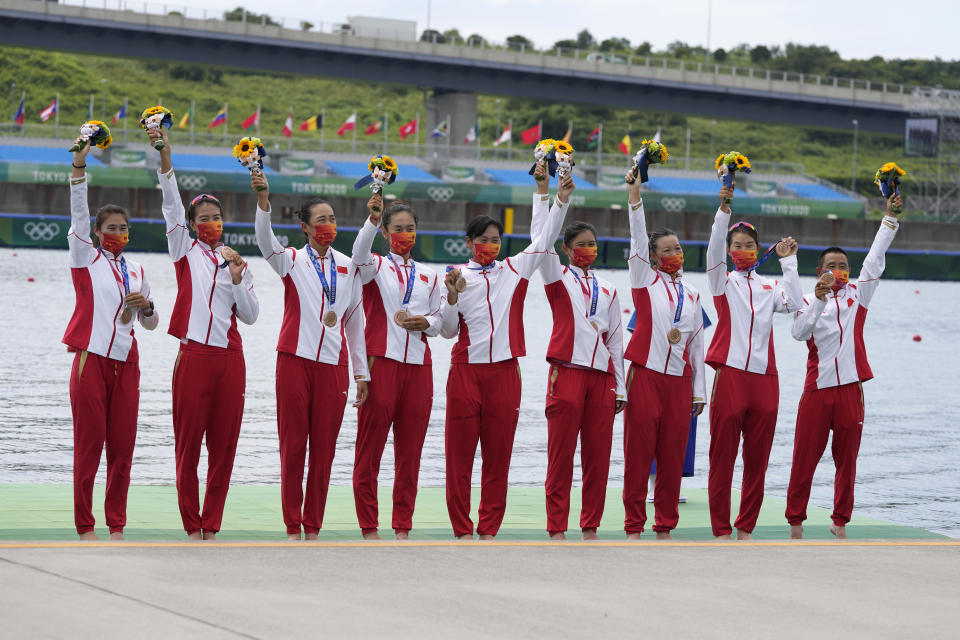 Wang Zifeng, Wang Yuwei, Xu Fei, Miao Tian, Zhang Min, Ju Rui, Li Jingjing, Guo Linlin, and Zhang Dechang of China celebrate winning the bronze medal for the women's rowing eight final at the 2020 Summer Olympics, Friday, July 30, 2021, in Tokyo, Japan. (AP Photo/Lee Jin-man)