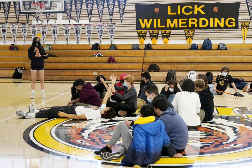 FILE - Lick-Wilmerding High School sophomore student leader Alia, left, speaks to students during a freshmen year Public Purpose Program workshop at the high school in San Francisco, March 9, 2022. U.S. COVID-19 cases are up, leading a smattering of school districts, particularly in the Northeast, to bring back mask mandates and recommendations for the first time since the omicron winter surge ended and as the country approaches 1 million deaths in the pandemic. (AP Photo/Jeff Chiu, File)