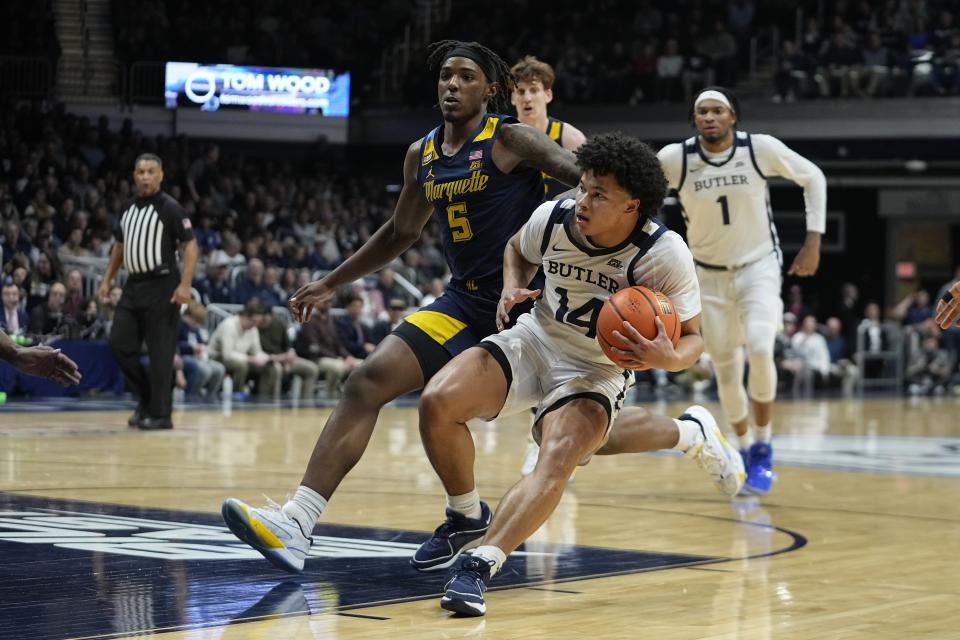 Butler's Landon Moore (14) goes to the basket against Marquette's Tre Norman (5) during the first half of an NCAA college basketball game Tuesday, Feb. 13, 2024, in Indianapolis. (AP Photo/Darron Cummings)