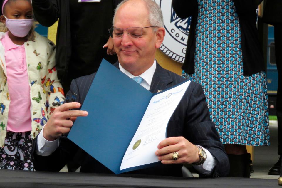 Louisiana Gov. John Bel Edwards shows one of many copies of a posthumous pardon he signed,Wednesday, Jan. 5, 2022, in New Orleans, for Homer Plessy. Plessy was a Black man who could have passed for white but stated his race and refused to leave a "whites only" train car in 1892, in an unsuccessful attempt to overturn a Jim Crow law segregating trains in Louisiana.