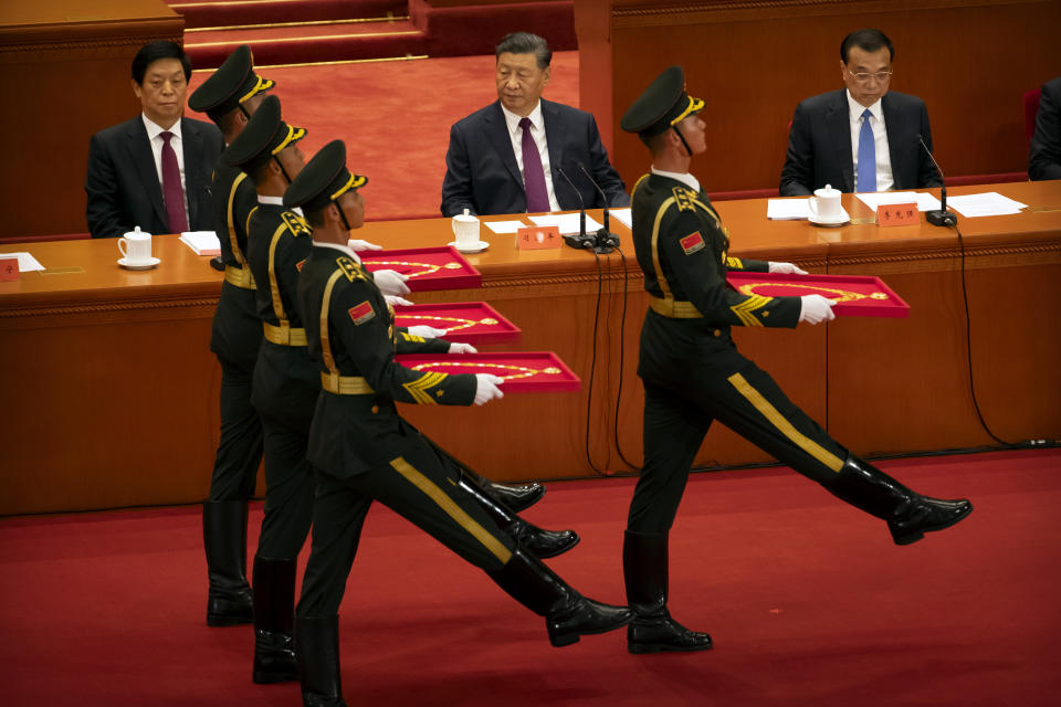 Chinese President Xi Jinping, center, watches as an honor guard carrying medals marches at an event to honor some of those involved in China's fight against COVID-19 at the Great Hall of the People in Beijing, Tuesday, Sept. 8, 2020. Chinese leader Xi Jinping is praising China's role in battling the global coronavirus pandemic and expressing support for the U.N.'s World Health Organization, in a repudiation of U.S. criticism and a bid to rally domestic support for Communist Party leadership. (AP Photo/Mark Schiefelbein)