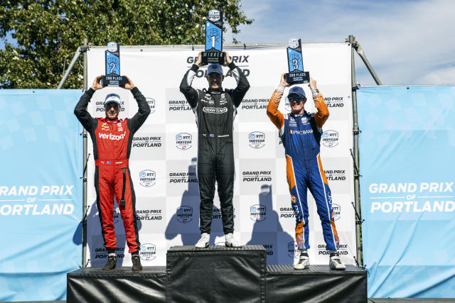 Scott McLaughlin middle, celebrates his victory at the podium with second place finisher Will Power, left, and third place finisher Scott Dixon after the Grand Prix of Portland IndyCar auto race at the Portland International Raceway in Portland, Ore., on Sunday, Sept. 4, 2022. (Naji Saker/The Oregonian via AP)