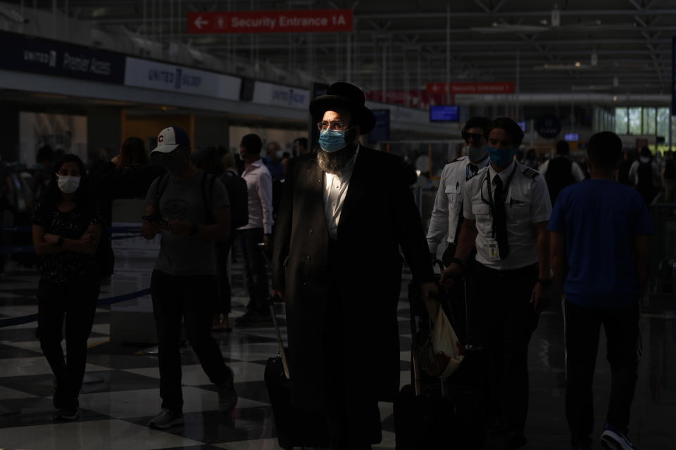 FILE - A shaft of light illuminates a passenger before boarding a flight at O'Hare International Airport in Chicago ahead of Fourth of July weekend, July 1, 2021. Loneliness in America can be deadly. In May 2023, U.S. Surgeon General Vivek Murthy declared it an American epidemic, saying that it takes as deadly a toll as smoking upon the population of the United States. “Millions of people in America are struggling in the shadows," he said, “and that’s not right.” (AP Photo/Shafkat Anowar, File)