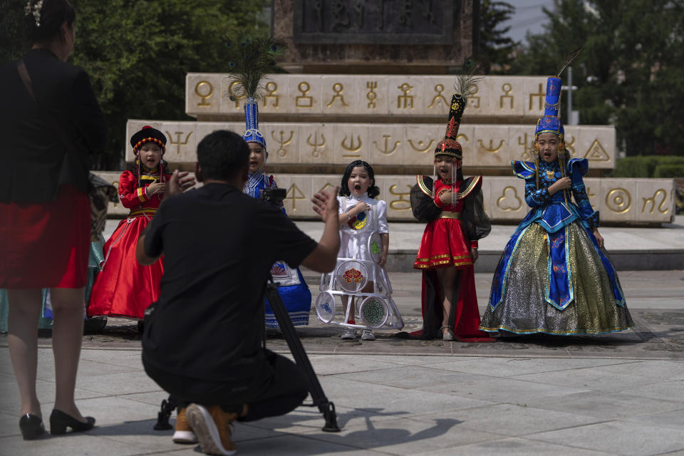 Mongolian children in traditional costumes sing the national anthem for a cameraman in Ulaanbaatar, Mongolia, Monday, July 1, 2024. (AP Photo/Ng Han Guan)