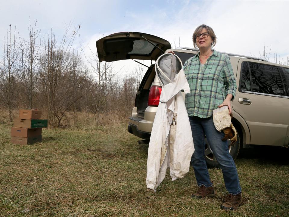 Nina Bagley, apiary inspector for Franklin County, tended to her own bee hives Thursday on Columbus' West Side. Her car held her protective gear, fresh frames to put in the hives, and sugar to keep the bees fed -- a must when bees are active on warmer winter days.